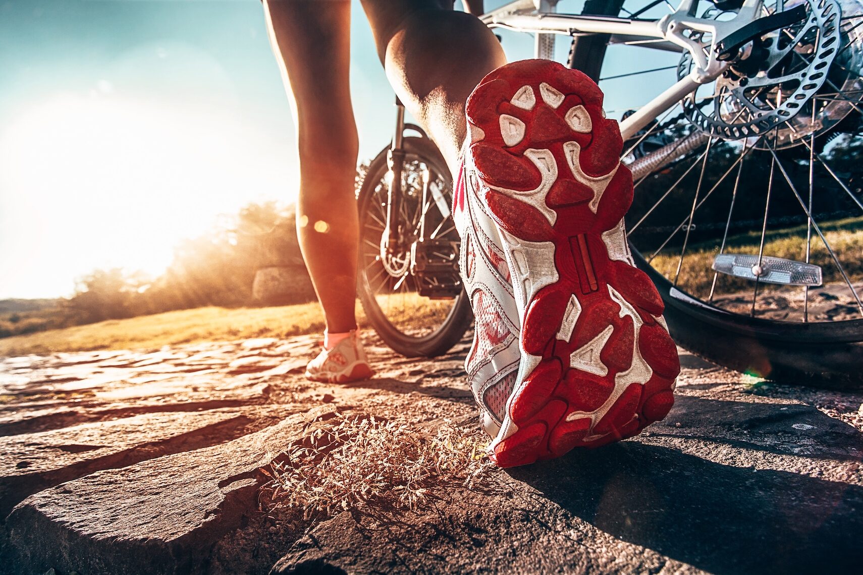 Athlete woman is running with her extreme mountain bike outdoors